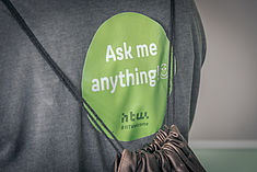 Sticker "Ask me anything" auf einem T-Shirt