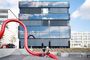 Zwei Studierende sitzen auf Kunst am Bau auf dem Campus Wilhelminenhof