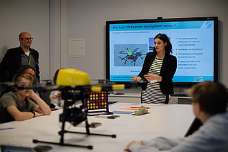 Wissenschaftlerin bei einem Vortrag über eine Drohne