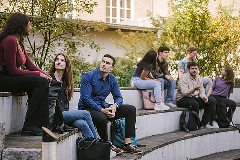 Studierende im Gespräch auf Sitzflächen im Innenhof © HTW Berlin/Alexander Rentsch