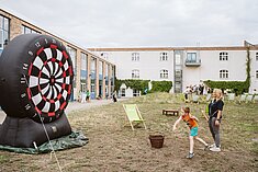 Kind spielt Riesen-Dart 