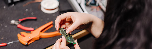 Studentin experimentiert mit einem Bauteil