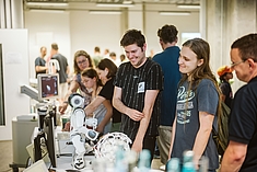 Besucher*innen sind von einem Roboter fasziniert