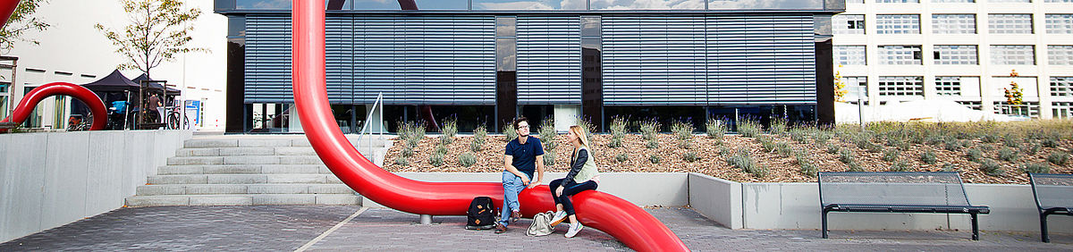 Zwei Studierende sitzen auf Kunst am Bau auf dem Campus Wilhelminenhof © HTW Berlin/Maria Schramm
